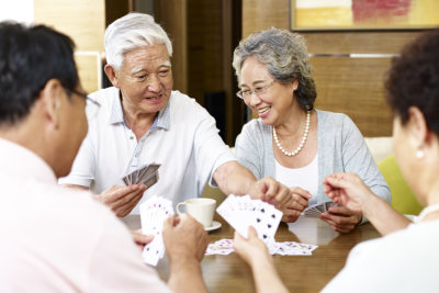 group of elderly people playing cards